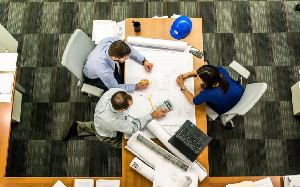 3 personnes travaillent autour d'une table